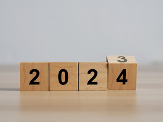 Wood cubes or blocks on table, turn of year from 2023 to 2024.