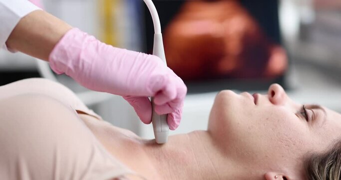 The doctor makes a woman an ultrasound of the thyroid gland, a close-up of the face. Diagnosis of thyroiditis, Medical instruments