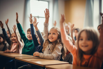 Students raising their hands in class at the elementary school - obrazy, fototapety, plakaty