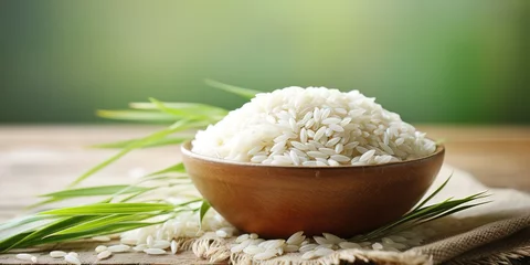 Fototapeten White rice and brown rice in a bowl on a background of green leaves. © Zaleman