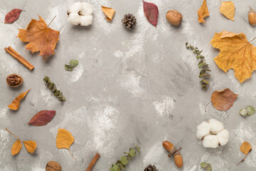 Autumn leaves with decor on concrete background, top view