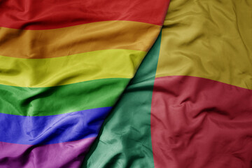 big waving realistic national colorful flag of benin and rainbow gay pride flag .