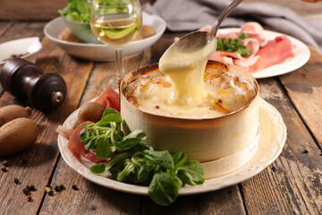 Traditional French winter dish- cheese fondue with charcuterie- Mont D'Or