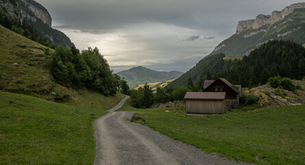 Alpine mountain landscape during a rainy day. Hiking path in the Swiss Alps with small wooden barn. Near Bachalpsee, a natural Swiss mountain lake. Rainy day.
