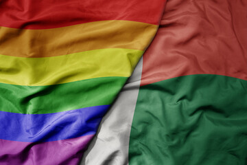 big waving realistic national colorful flag of madagascar and rainbow gay pride flag .