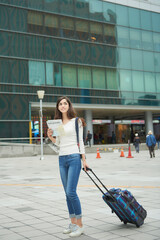  A woman wearing a backpack and looking at a map at a Korean train station