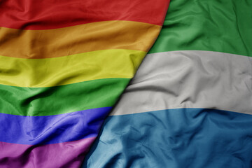 big waving realistic national colorful flag of sierra leone and rainbow gay pride flag .