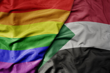 big waving realistic national colorful flag of sudan and rainbow gay pride flag .