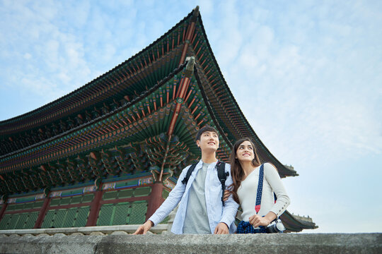 A couple traveling in Korea with a backpack and a camera