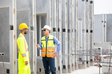 building and construction worker, Hiapanic latin male wearing safety hard hat helmet standing at Prefabricated concrete walls Industry Manufacturing Factory. Unity and teamwork