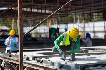 Labor man cutting steel at the construction site. Heavy Industry Manufacturing Factory. Prefabricated concrete walls. Asian worker wearing safety hardhat helmet