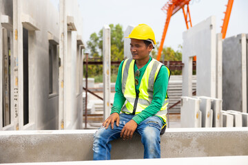 Tired hot wiping sweat. Asian worker enjoying free time. forman warehouse worker sitting on workshop site break relax time at Heavy Industry Manufacturing Prefabricated concrete walls Factory