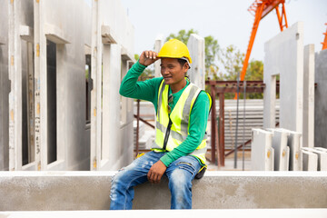 Tired hot wiping sweat. Asian worker enjoying free time. forman warehouse worker sitting on workshop site break relax time at Heavy Industry Manufacturing Prefabricated concrete walls Factory