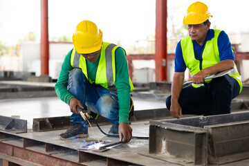 welding. Asian man worker weld metal with a arc welding machine at the construction site. Heavy Industry Manufacturing Factory. Prefabricated concrete walls