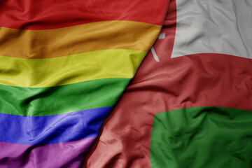 big waving realistic national colorful flag of oman and rainbow gay pride flag .