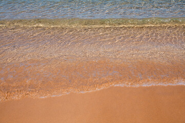Beach background. Calm beautiful ocean wave on sandy beach. Sea view from tropical sea beach.