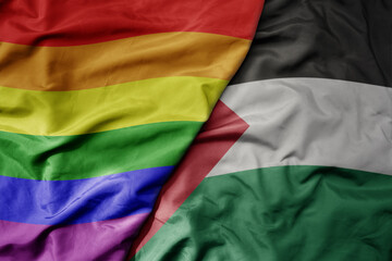 big waving realistic national colorful flag of palestine and rainbow gay pride flag .