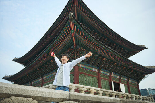 A young man with a loudspeaker guided by a tour guide at a Korean tourist attraction
