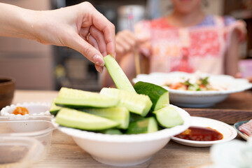 食卓で胡瓜をつまむ女性の手