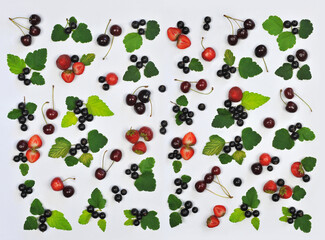 Set with fresh red and black berries on white background .Summer fruit -berry background with ripe cherries ,strawberries , black currant  and green leaves  Top view flat lay.