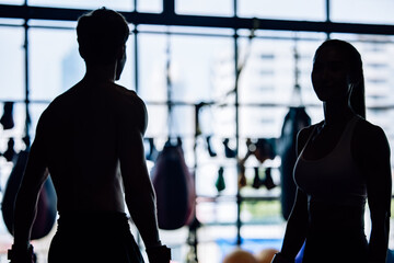 Silhouette shot of kickboxing enthusiasts routinely build strength, endurance, discipline at the gym