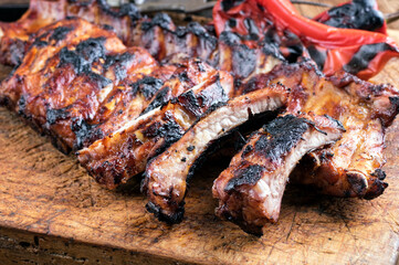 Barbecue veal spare ribs with hot honey chili served as close-up on a rustic old wooden board