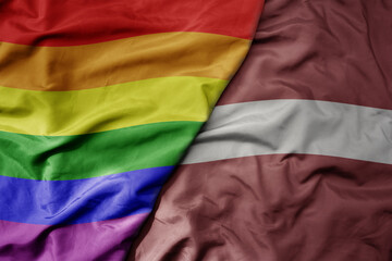 big waving realistic national colorful flag of latvia and rainbow gay pride flag .