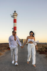 Pareja paseando por la carretera del faro