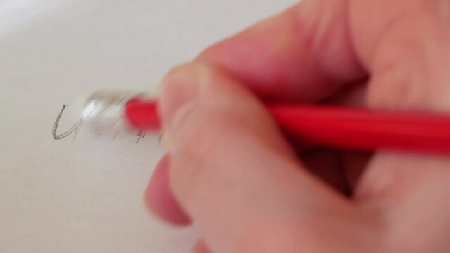 hand erasing the negative part of a word unnatural with an eraser on a sheet of paper