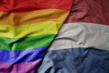 big waving realistic national colorful flag of netherlands and rainbow gay pride flag .