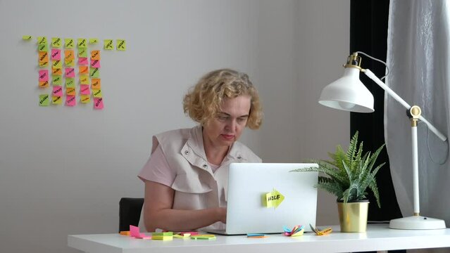 Businesswoman with laptop on agile board background. Using scrum board for task control is a kind of agile development methodology