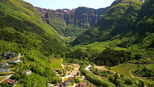 Drone footage over Geiranger fjord and fjord in Norway with green Alps with snowy top