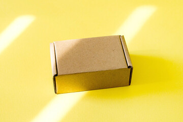 Cardboard kraft boxes on a yellow background. Packing the parcel.
