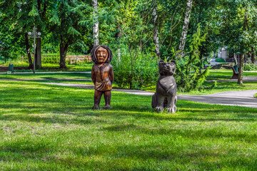 Trostyanets, Sumy Oblast, Ukraine - June 18, 2023: Wooden sculptures of a girl with a panther on a...