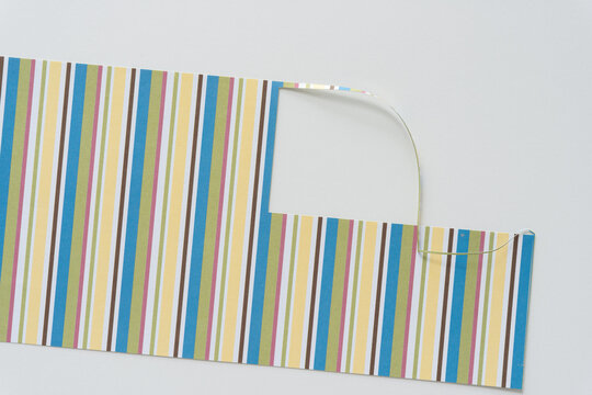 striped paper with squarish cutout on blank paper