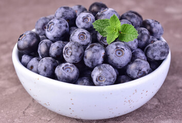 Blueberries in a bowl on a gray background.Close-up.
