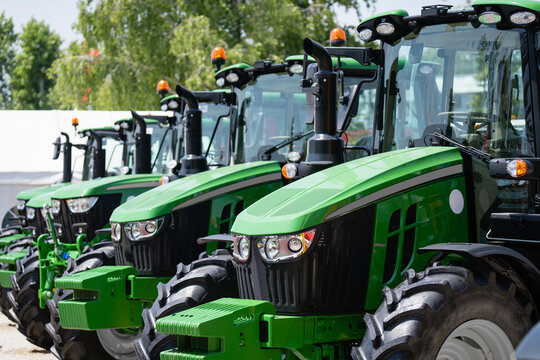 Fototapeta A row of green agricultural tractors