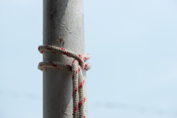 knotted rope and pole outdoors (on a light blue sky)