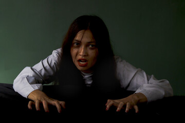 Halloween scary dead woman in spooky white ghost costume in dark background, black long hair female...