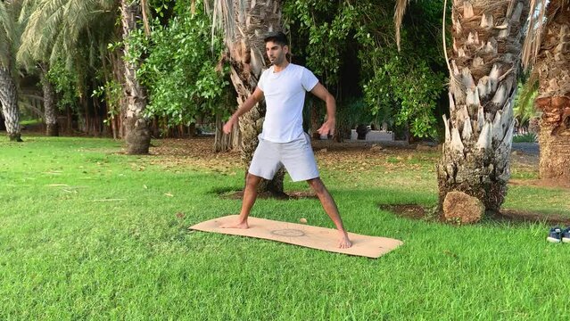 Joven indio entrenando yoga. Sesi&oacute;n de fitness en colchoneta en el parque. Relax al aire libre para una buena salud. Ejercicios para una mejor movilidad por las ma&ntilde;anas en verano en canarias. 