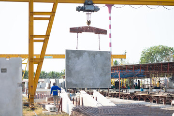 Naklejka premium Background banner. Large cranes moving prefabricated walls in factories. Prefabricated concrete walls for building office buildings and residential houses. reinforced concrete wall