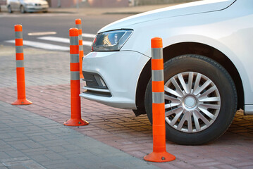 Car parked close to warning post at parking lot. Car parked close to flexible orange traffic...