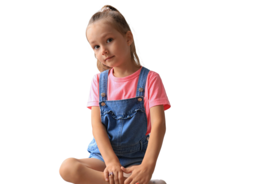 Excited child looking at camera while sitting on a transparent background