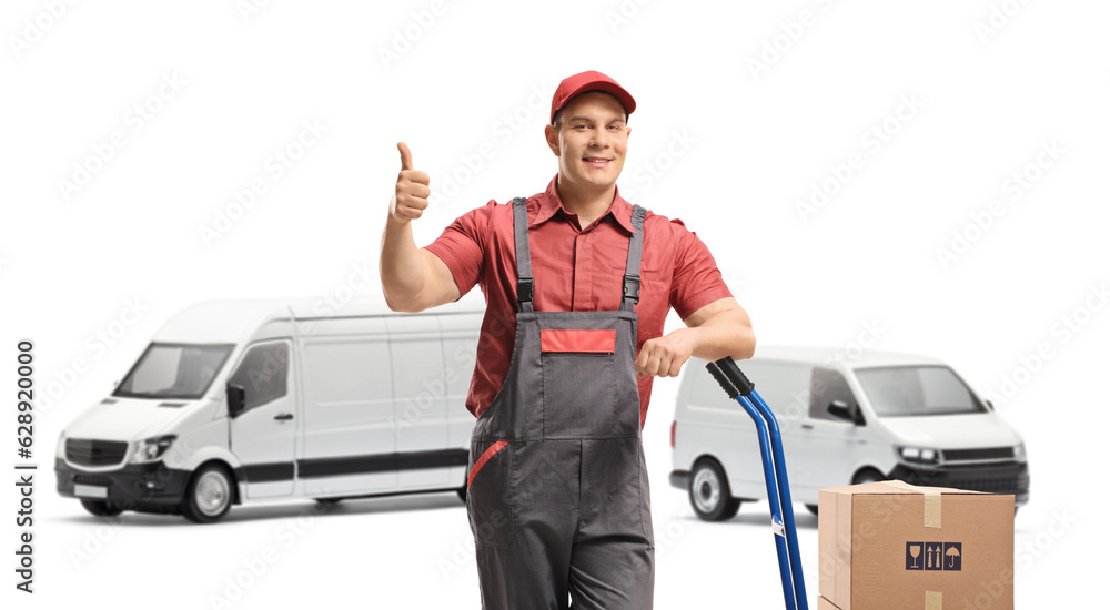 Wall mural Worker leaning on a hand truck loaded with boxes making a thumb up gesture in front of transporting vans