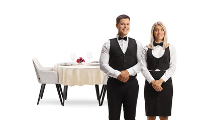 Male and female ervers in uniforms posing in front of a table