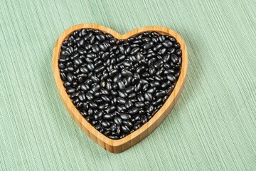 heart shaped black bean bowl on green tablecloth
