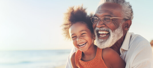 Portrait of happy African American grandfather and granddaughter on the beach. Concept of friendly family.