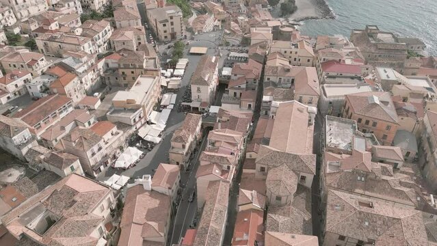 4k 25fps footage: aerial view of the medieval village of Pizzo in Calabria with its Murat castle, the Caribbean sea, the highway behind. The town is overlooking the sea.