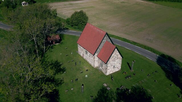 Drone footage of Berg Old Church (Berg steinkirke) in Larvik countryside lawns in Norway