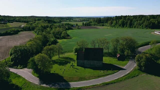 Drone footage of Berg Old Church with countryside and trees in Larvik, Norway